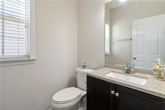 half bathroom with toilet and vanity