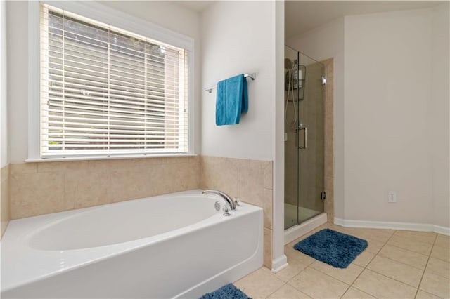 full bath featuring healthy amount of natural light, tile patterned floors, a shower stall, and a garden tub