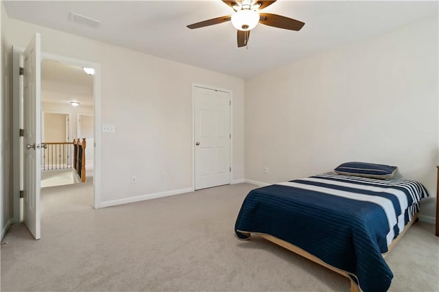bedroom featuring light colored carpet, baseboards, and a ceiling fan