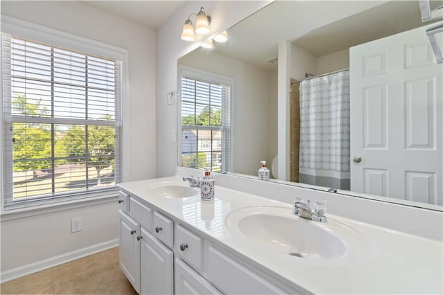 bathroom with baseboards, tile patterned flooring, double vanity, and curtained shower