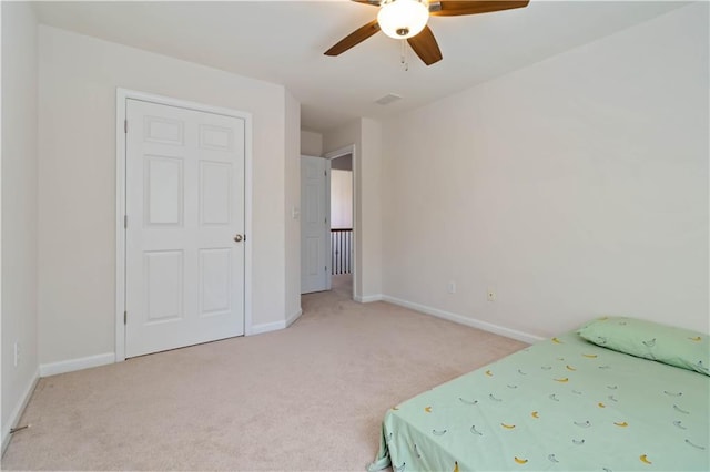bedroom featuring light colored carpet, baseboards, and ceiling fan