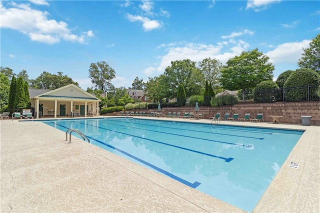 community pool featuring fence and a patio area
