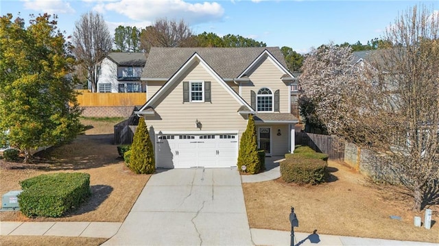 traditional home with a garage, driveway, and fence