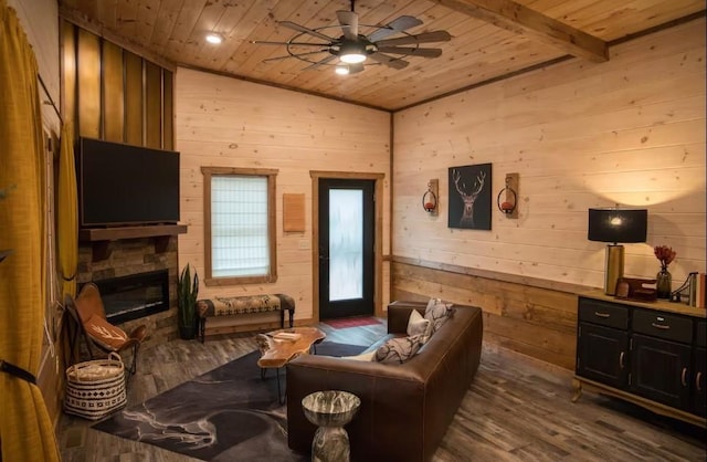 living room featuring a stone fireplace, wood walls, vaulted ceiling with beams, dark wood-type flooring, and wooden ceiling