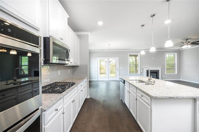 113 Canal St, Hampton, GA 30228 - kitchen featuring stainless steel appliances, a sink, open floor plan, ornamental molding, and a fireplace