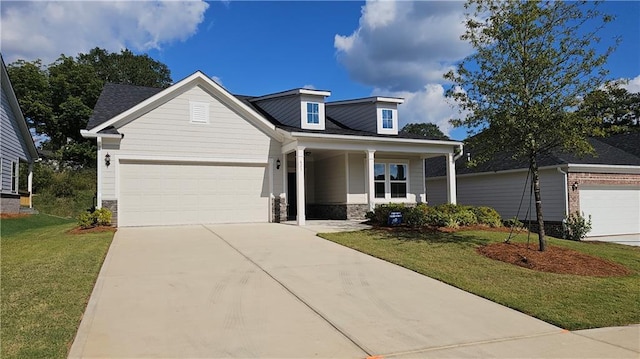 view of front of property with a garage, a front lawn, and a porch