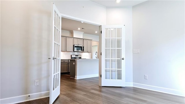 interior space featuring tasteful backsplash, hardwood / wood-style floors, stainless steel appliances, and french doors