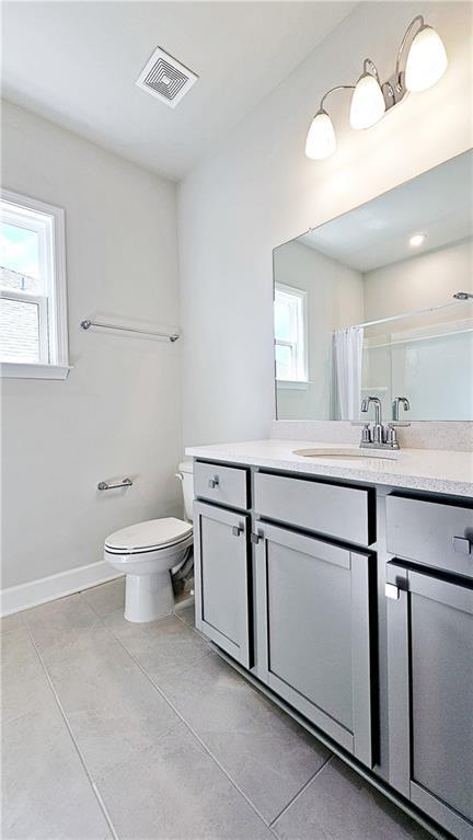 bathroom with vanity, a healthy amount of sunlight, curtained shower, and toilet