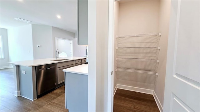 kitchen with dishwasher, wood-type flooring, sink, gray cabinetry, and a center island