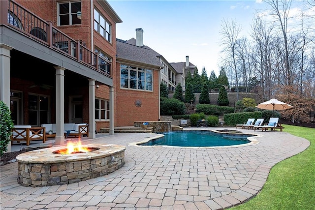 pool with a patio and a fire pit