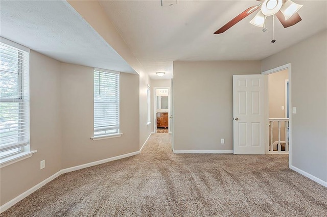 unfurnished room featuring carpet floors, ceiling fan, and baseboards