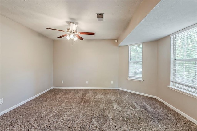 carpeted empty room featuring a ceiling fan and baseboards