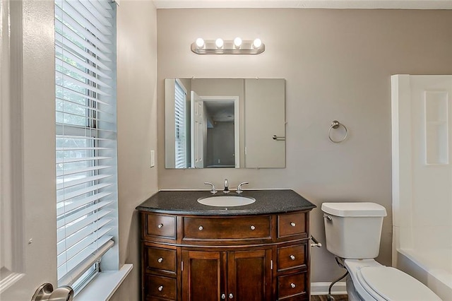 full bathroom with vanity, toilet, a tub, and baseboards
