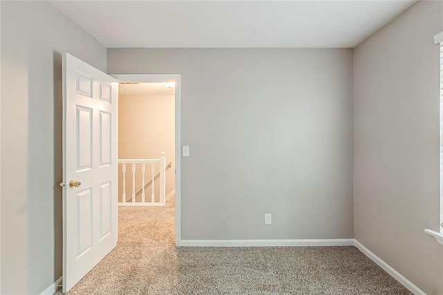 carpeted spare room featuring baseboards