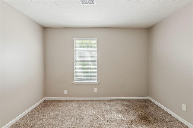 empty room featuring carpet floors and baseboards