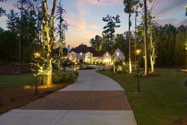 view of home's community featuring decorative driveway and a lawn