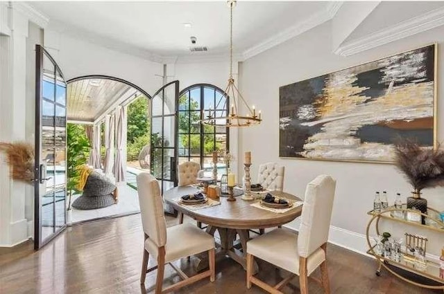 dining room featuring crown molding, wood finished floors, and a chandelier
