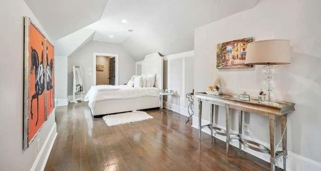 bedroom with wood finished floors, vaulted ceiling, and baseboards