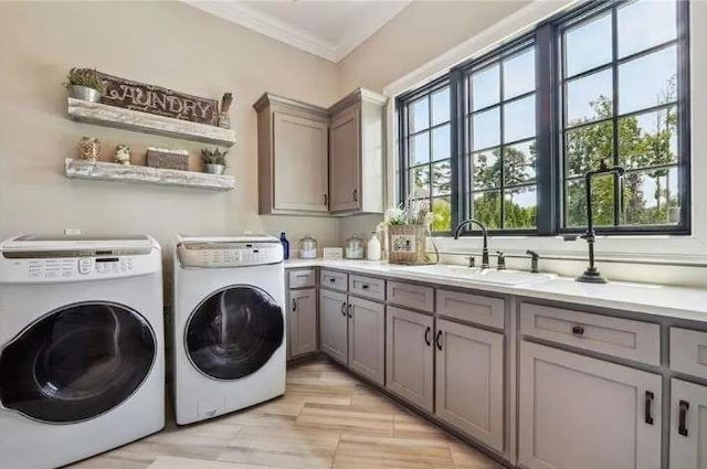 laundry room featuring washer and dryer, cabinet space, and ornamental molding