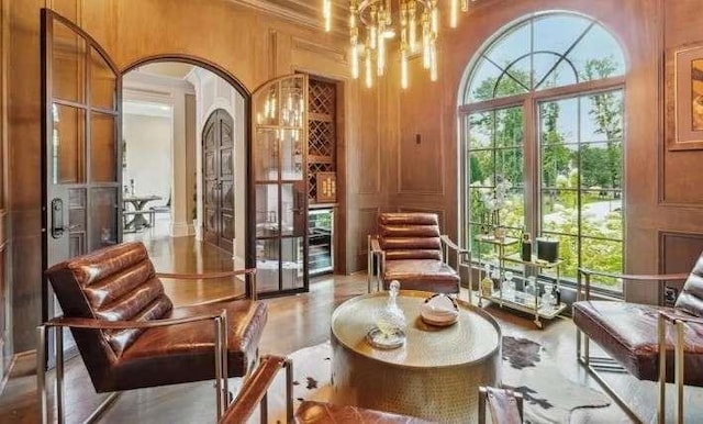 sitting room with a towering ceiling, a chandelier, and arched walkways