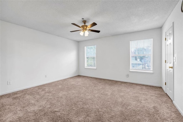 spare room with carpet, a textured ceiling, plenty of natural light, and ceiling fan