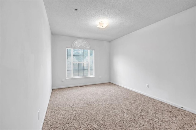 carpeted empty room with a textured ceiling