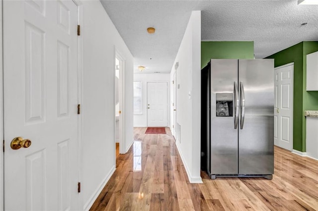 corridor featuring light hardwood / wood-style flooring and a textured ceiling