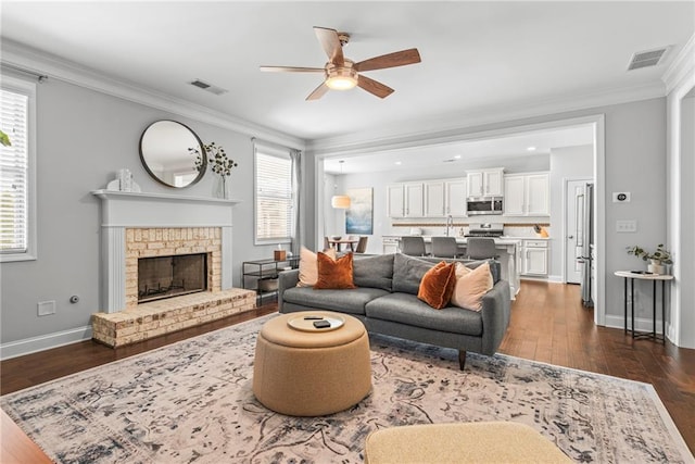 living room with ornamental molding, visible vents, and dark wood-style floors