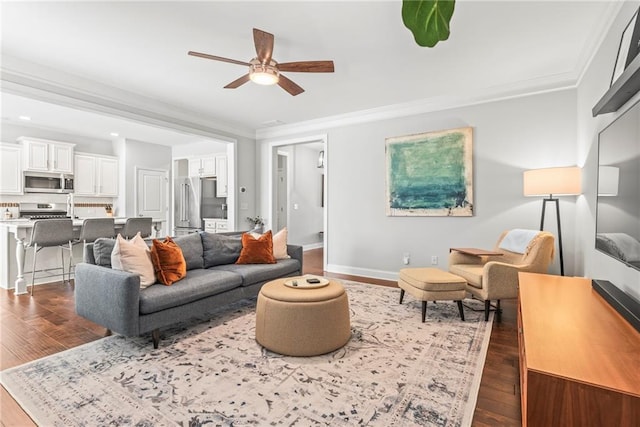 living area with ornamental molding, baseboards, and wood finished floors