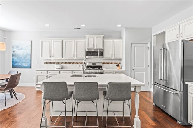 kitchen with dark wood-style floors, light countertops, visible vents, appliances with stainless steel finishes, and a sink