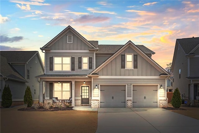 craftsman-style home featuring a porch, an attached garage, concrete driveway, roof with shingles, and board and batten siding