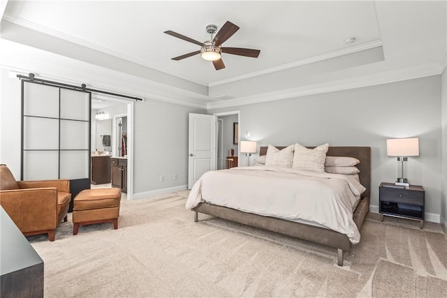 bedroom featuring a barn door, baseboards, ornamental molding, a tray ceiling, and carpet floors