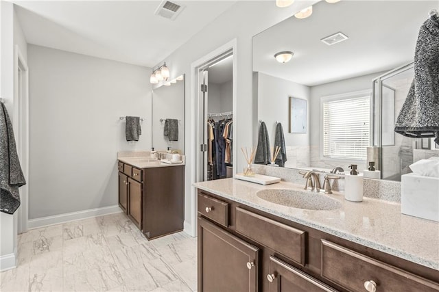 bathroom with two vanities, marble finish floor, visible vents, and a sink