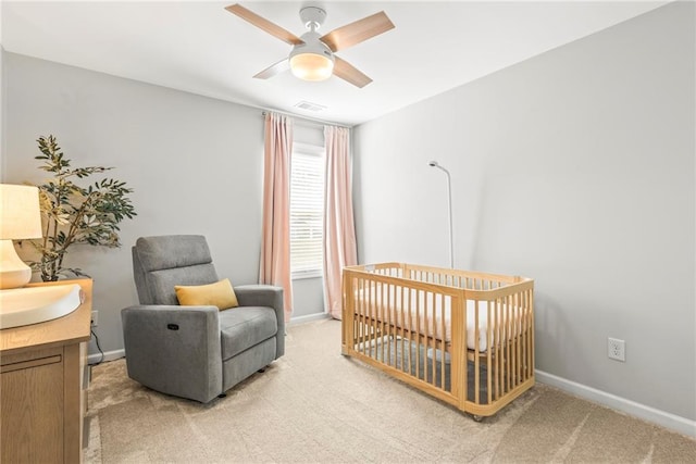 bedroom featuring baseboards, a crib, and light colored carpet