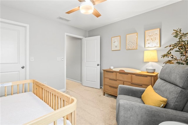 bedroom featuring baseboards, visible vents, a ceiling fan, and light colored carpet