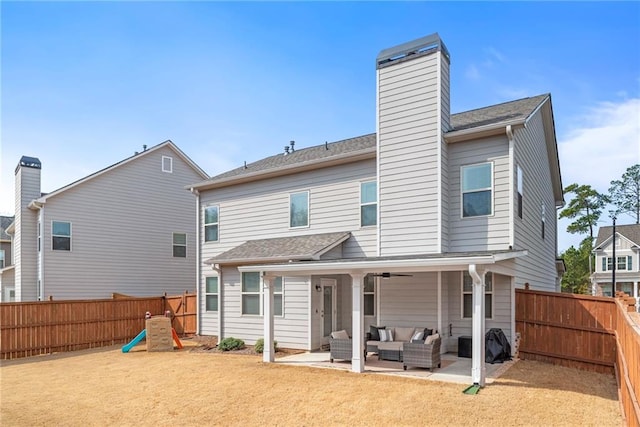 rear view of property with a patio, ceiling fan, a fenced backyard, a yard, and outdoor lounge area