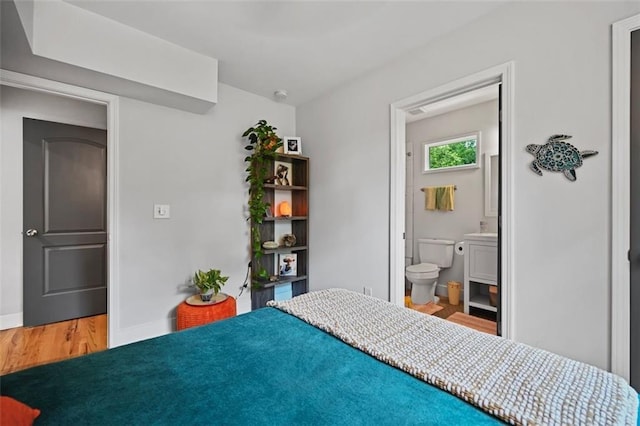 670 Parker Ave, Decatur, GA 30032 - bedroom featuring wood finished floors, baseboards, ensuite bath, and a sink