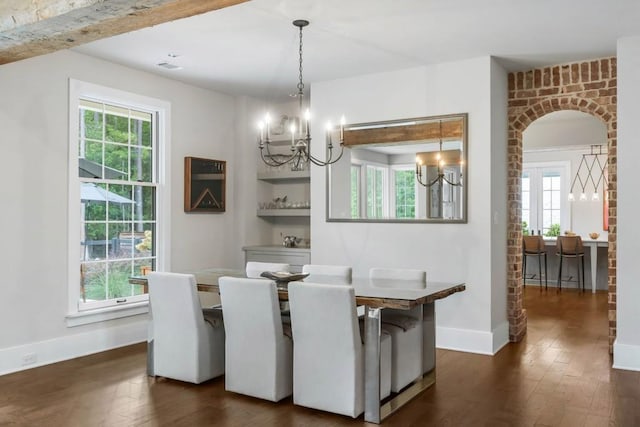 dining room featuring a chandelier, dark wood-style flooring, and plenty of natural light