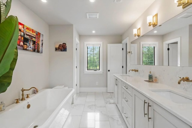 bathroom with a soaking tub, recessed lighting, double vanity, marble finish flooring, and baseboards