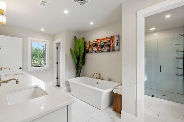 bathroom featuring a stall shower, a freestanding tub, recessed lighting, and vanity
