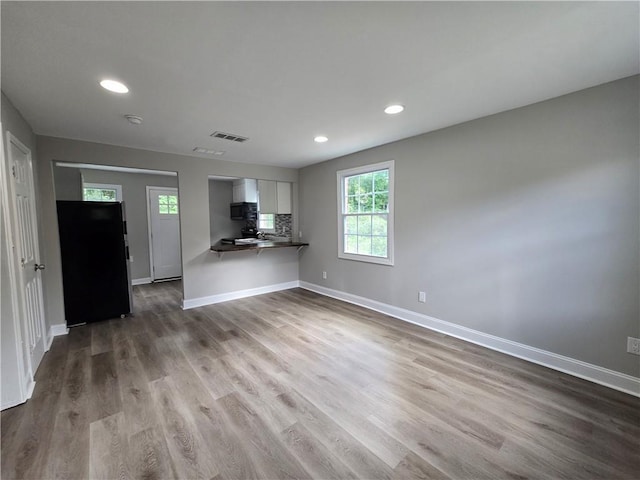 1753 Cahoon St SW, Atlanta, GA 30310 - kitchen with refrigerator, baseboards, wood finished floors, white cabinets, and recessed lighting