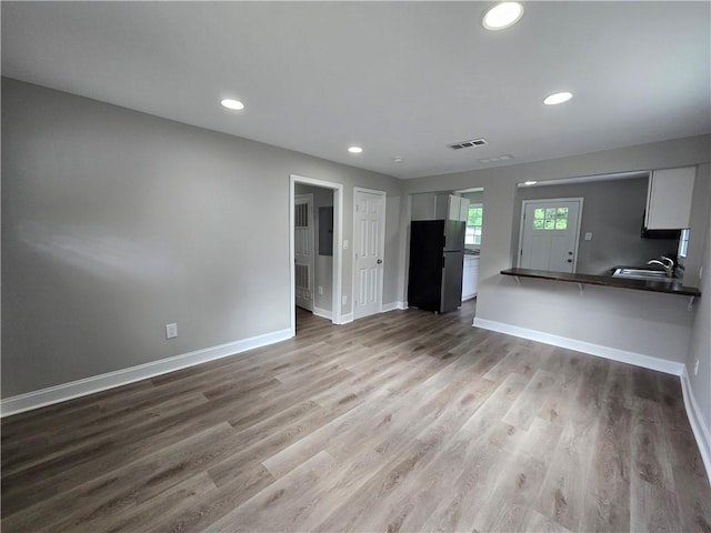 1753 Cahoon St SW, Atlanta, GA 30310 - unfurnished living room featuring baseboards, a sink, wood finished floors, and recessed lighting
