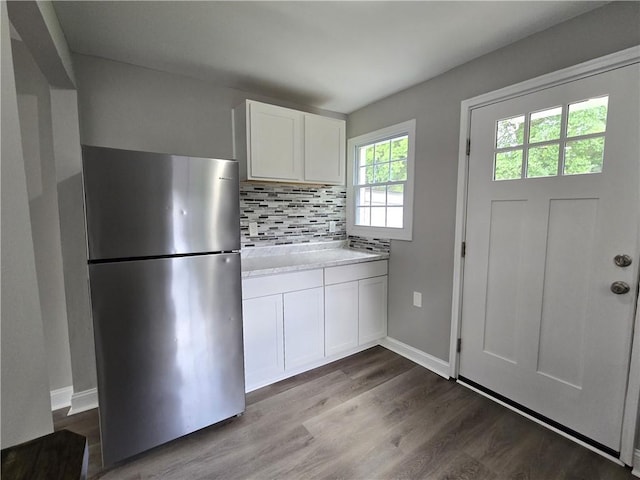 1753 Cahoon St SW, Atlanta, GA 30310 - kitchen with freestanding refrigerator, decorative backsplash, dark wood-style flooring, white cabinets, and baseboards