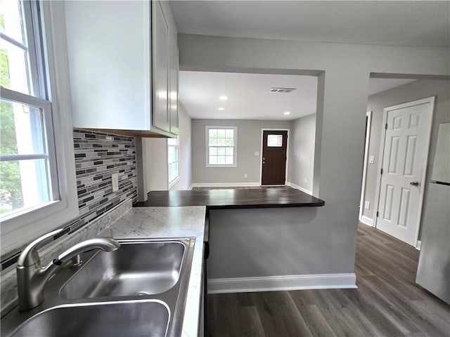 1753 Cahoon St SW, Atlanta, GA 30310 - kitchen featuring a sink, backsplash, dark wood-style flooring, baseboards, and freestanding refrigerator