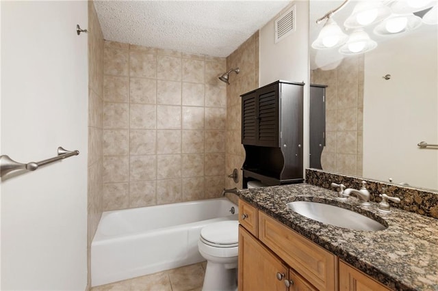 full bathroom featuring tiled shower / bath, tile patterned flooring, vanity, toilet, and a textured ceiling