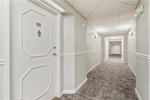 hallway with carpet and a drop ceiling