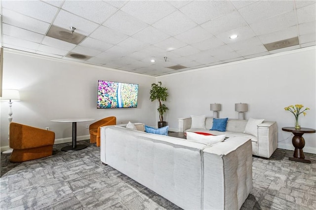 living room featuring light carpet and a drop ceiling