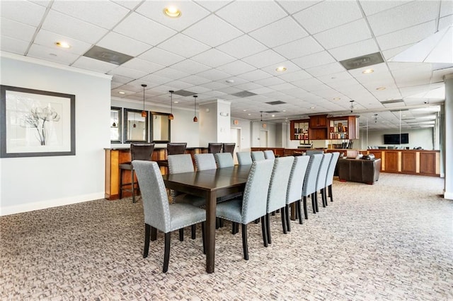 dining room featuring light colored carpet and a paneled ceiling