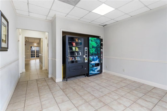 tiled empty room featuring a drop ceiling