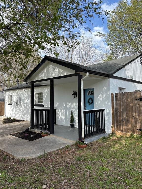 exterior space featuring stucco siding and fence